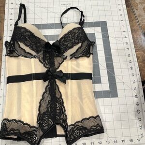 Cream and black fasten-back bustier. Exceptional pre-owned condition. Like new!!